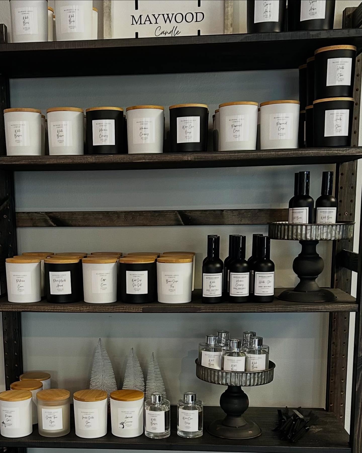 Maywood Candles with a variety of scented candles in glass jars, showcasing different fragrances and warm candlelight ambiance.